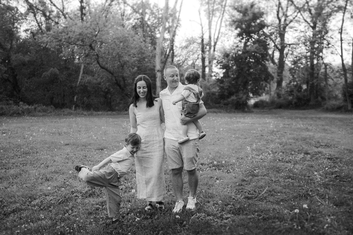 Several black and white photographs show people posing in an outdoor setting with trees and grass.