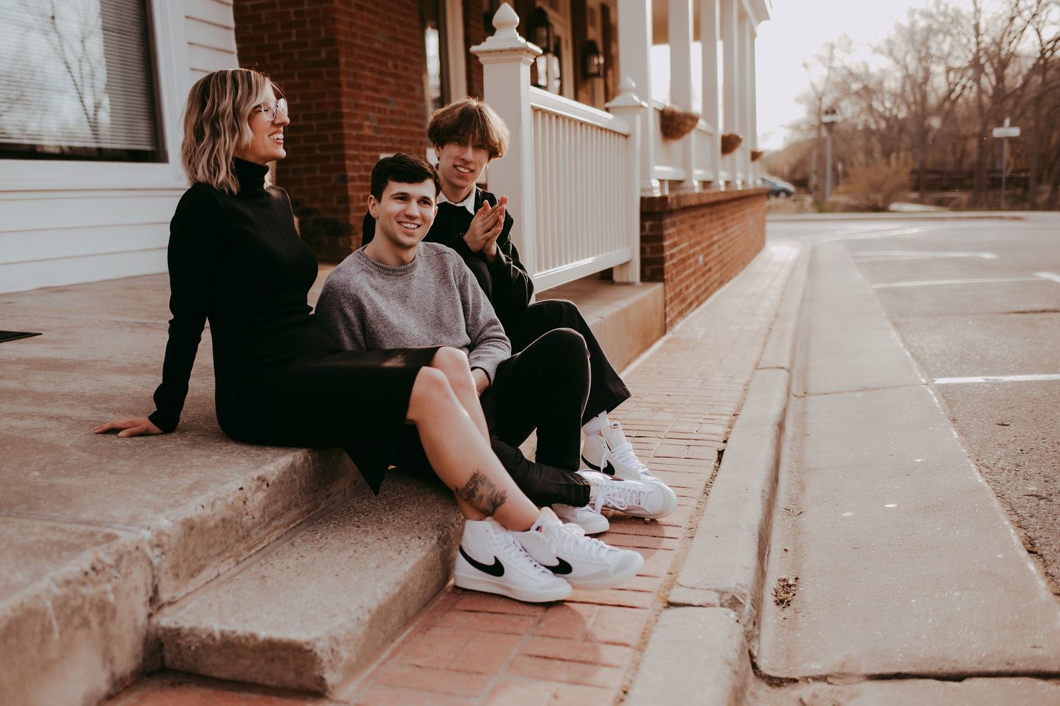 Candid group moment sitting on concrete steps outside a building.