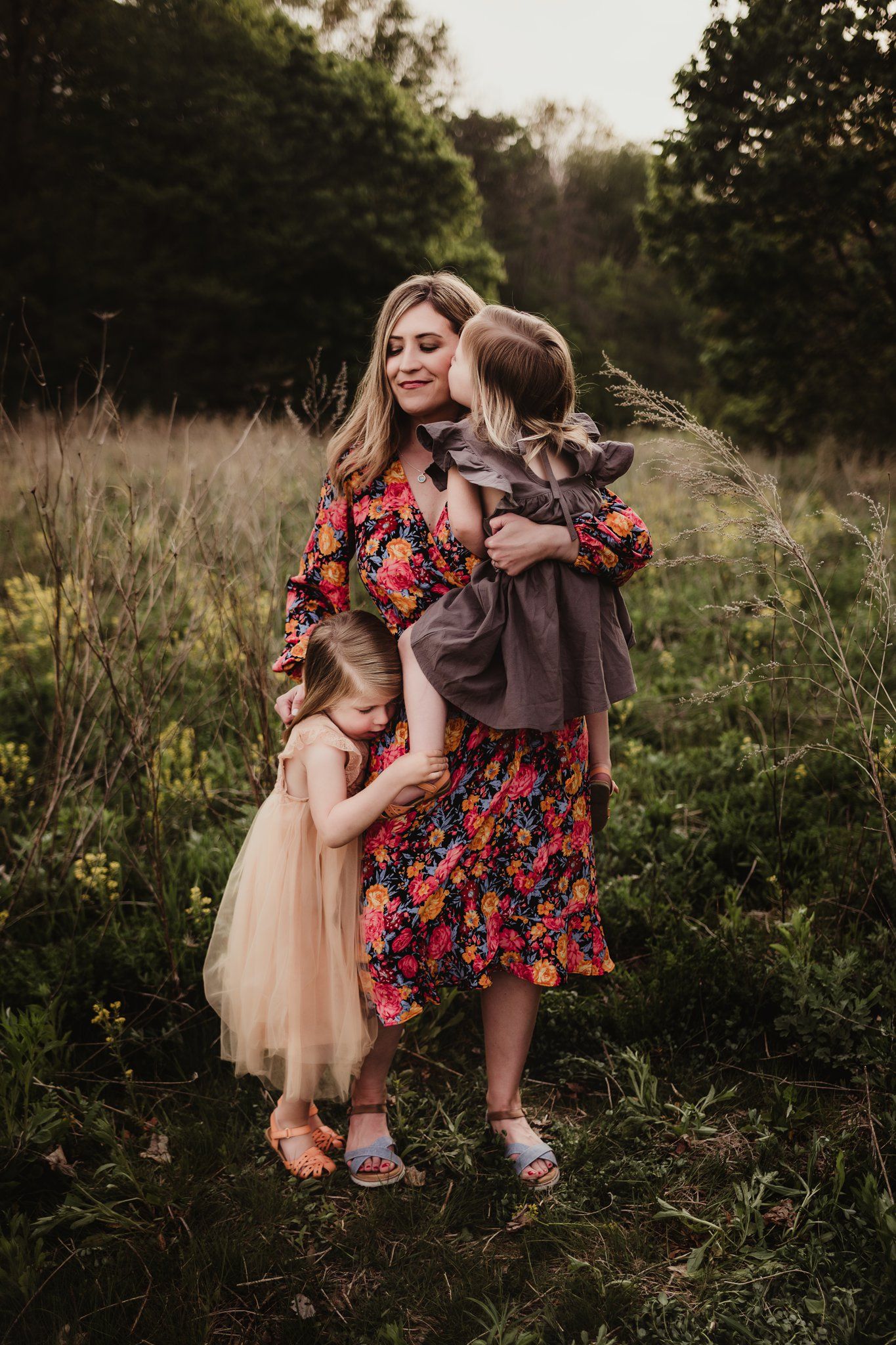 Intimate family moment captured in golden hour light with floral and muted dress coordination.