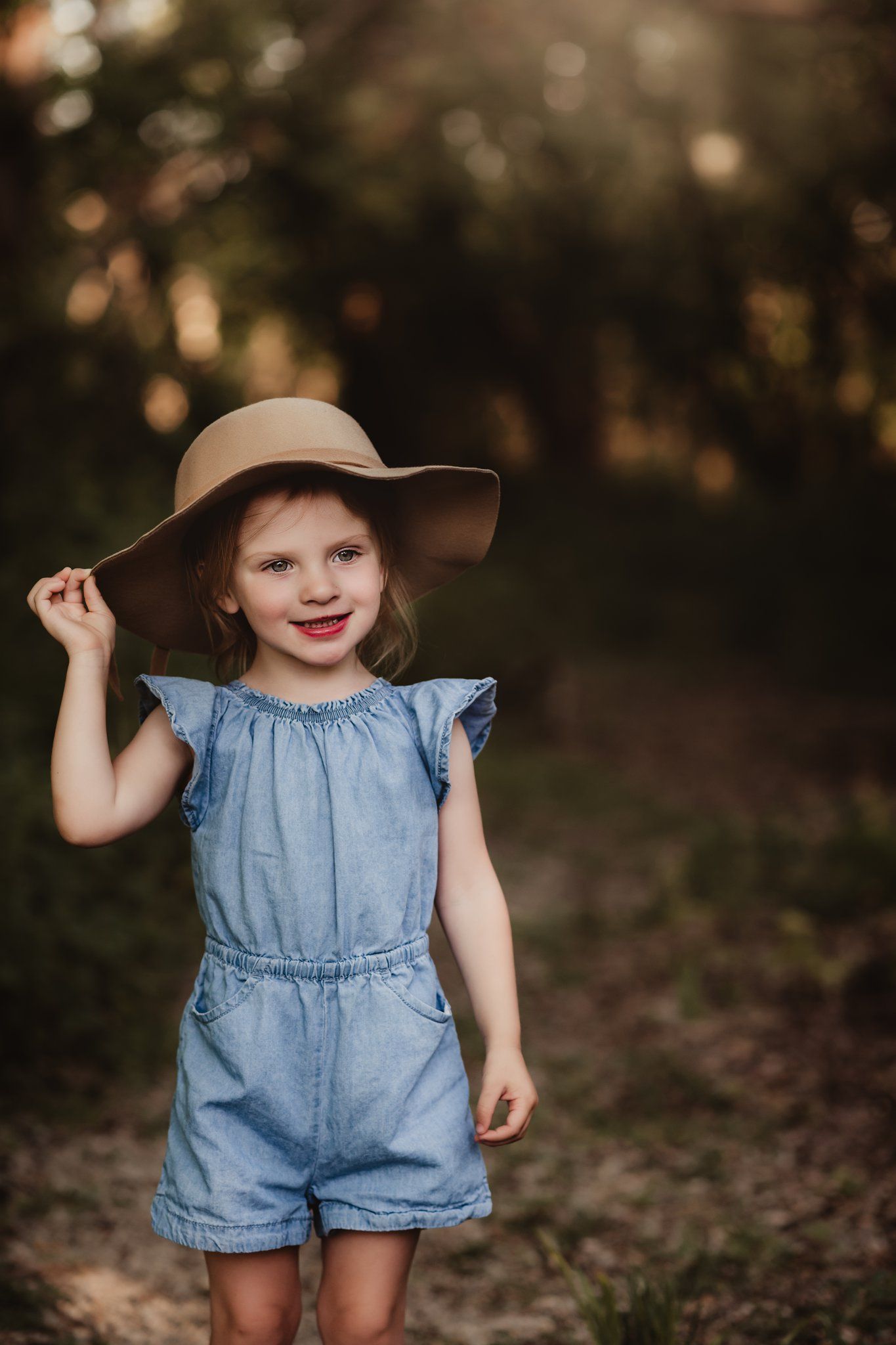 A joyful moment captured in denim and a floppy hat during golden hour.