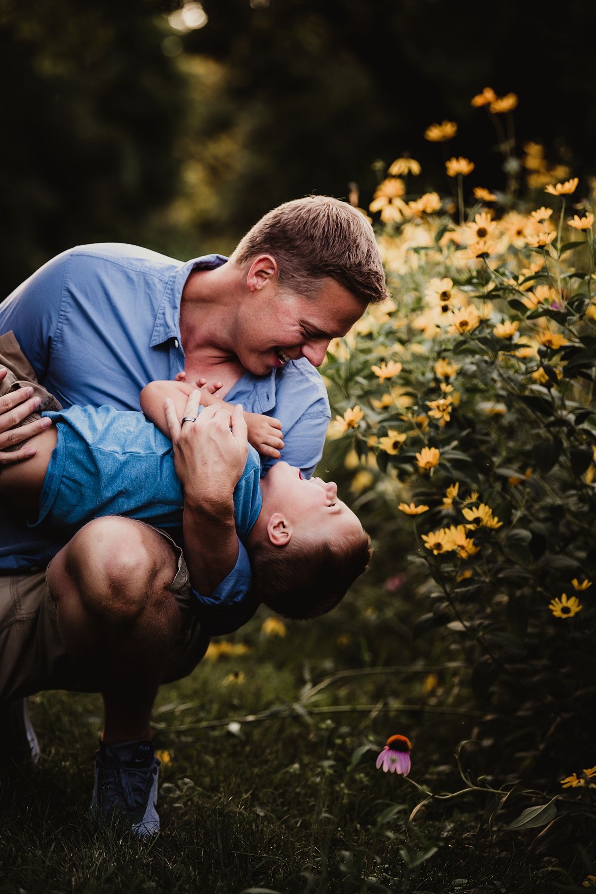 Playful outdoor portrait in garden setting with yellow wildflowers in background.