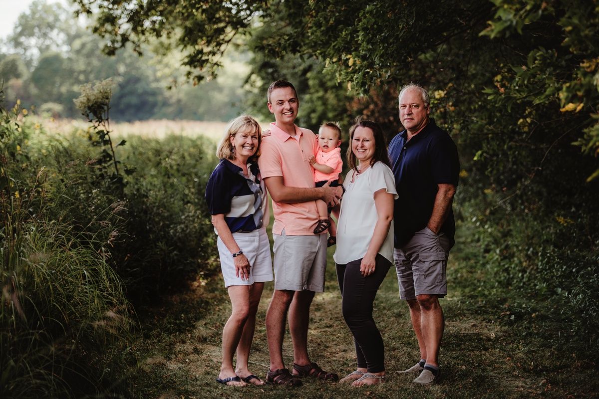A full family group portrait on a scenic nature path at dusk.