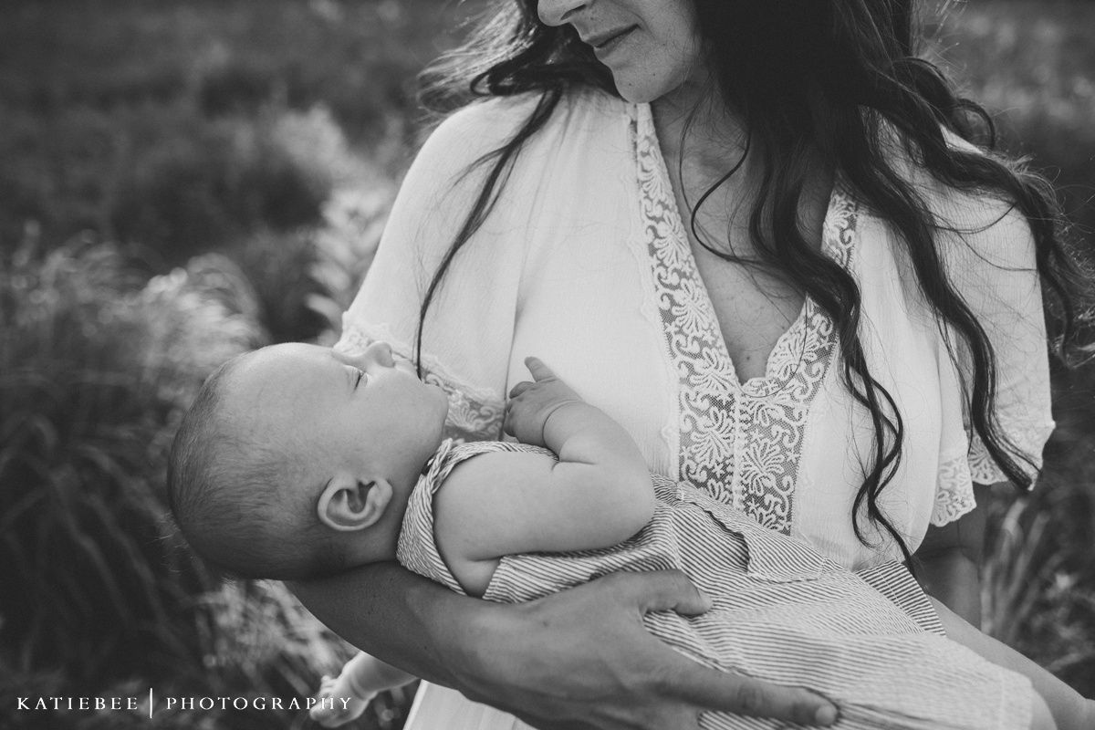 Intimate black and white portrait of nurturing moment between mother and infant.