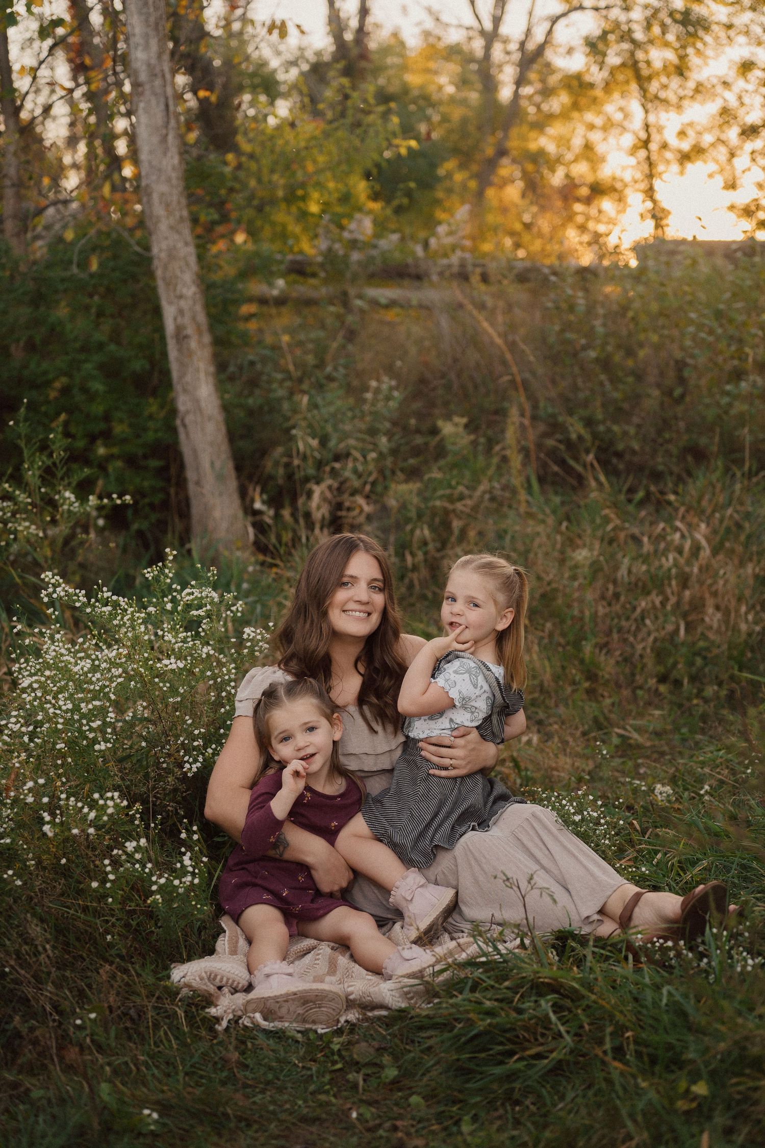 Family relaxing together in a wildflower meadow at sunset.