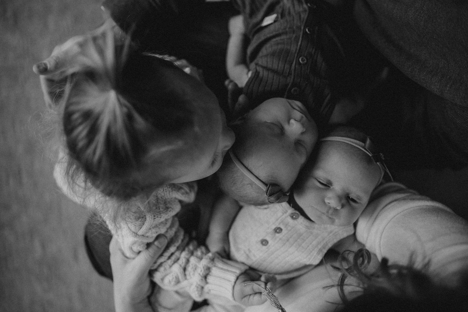 Black and white image of people gathered close together in an intimate family moment.