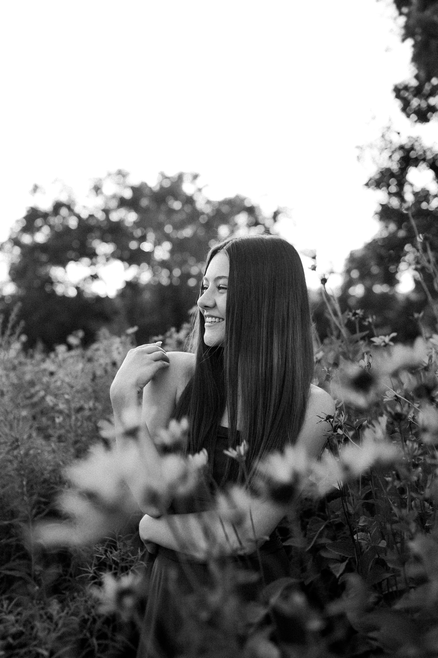 Artistic black and white close-up portrait taken among blooming wildflowers in natural lighting.