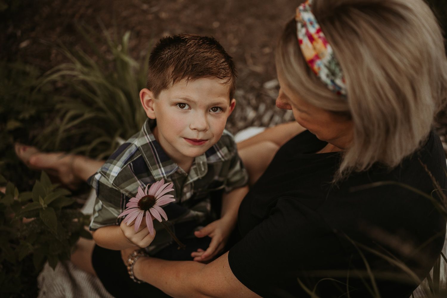 A joyful interaction while holding pink flowers in an outdoor garden setting.