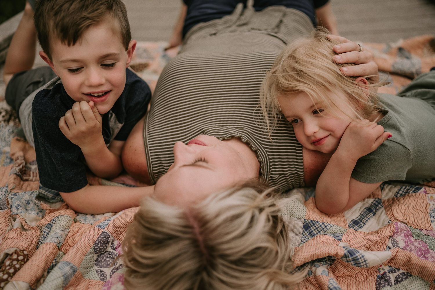 Playful moment captured on a patterned blanket during an outdoor photoshoot.