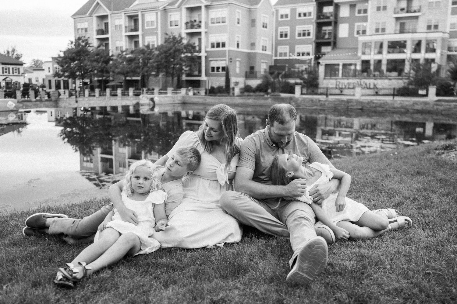 Black and white photo series showing children playing and relaxing together on grass in a residential neighborhood.