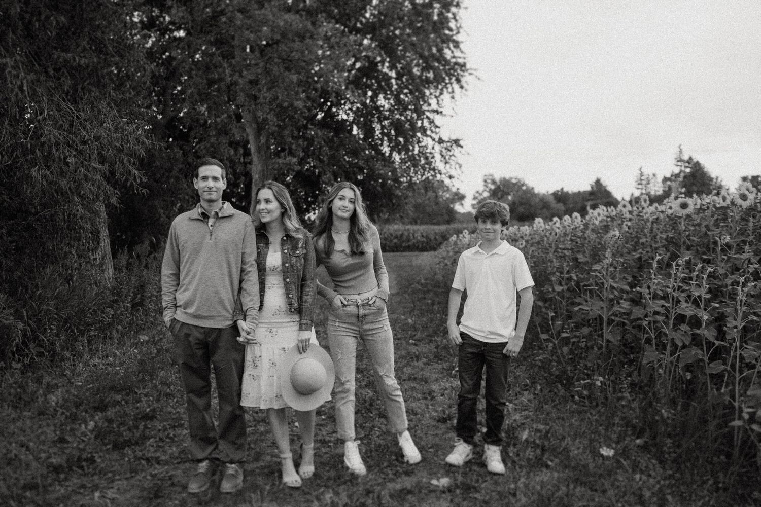 A black and white photo of a group walking along a countryside path.