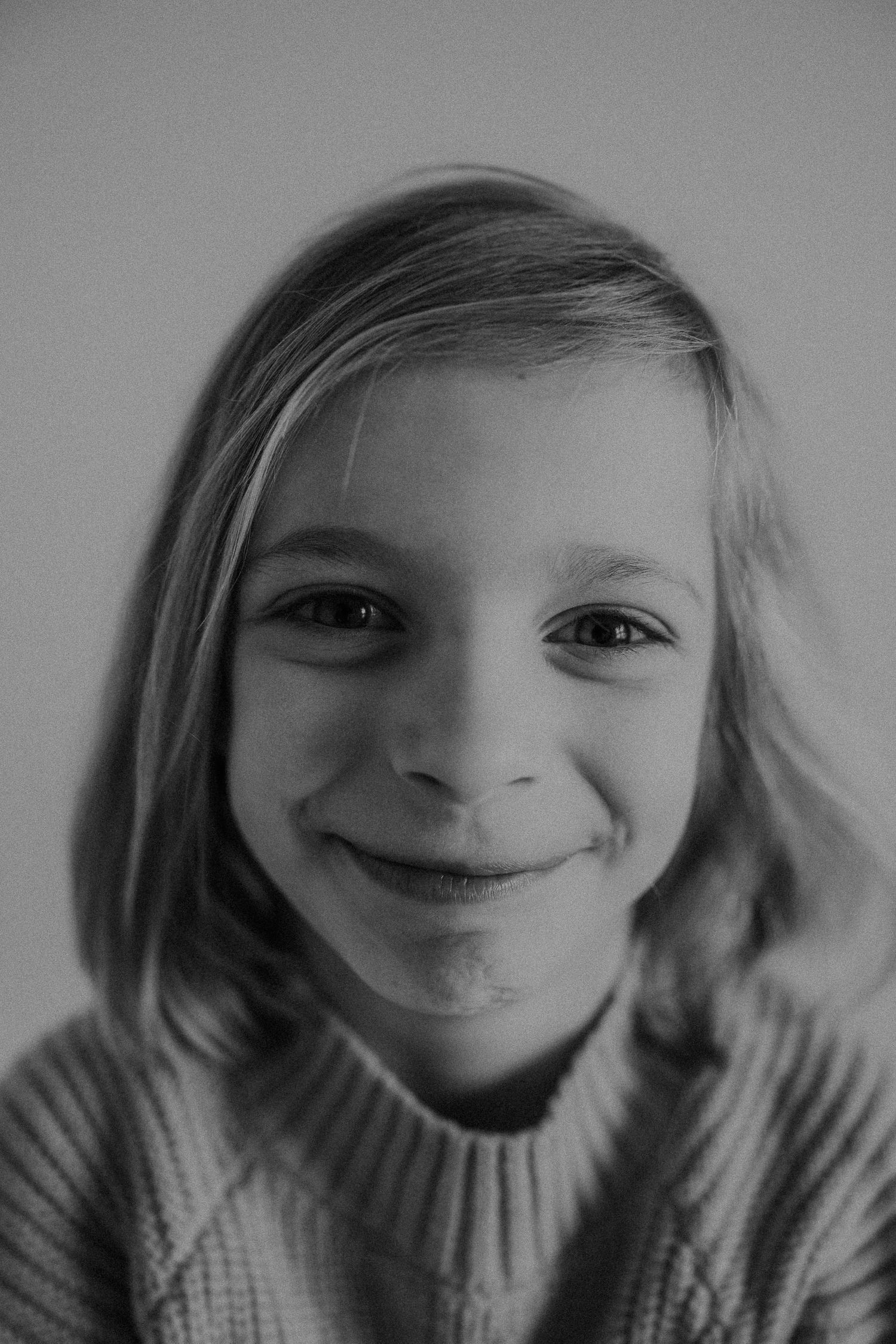 Close-up black and white portrait showing a warm, genuine smile.