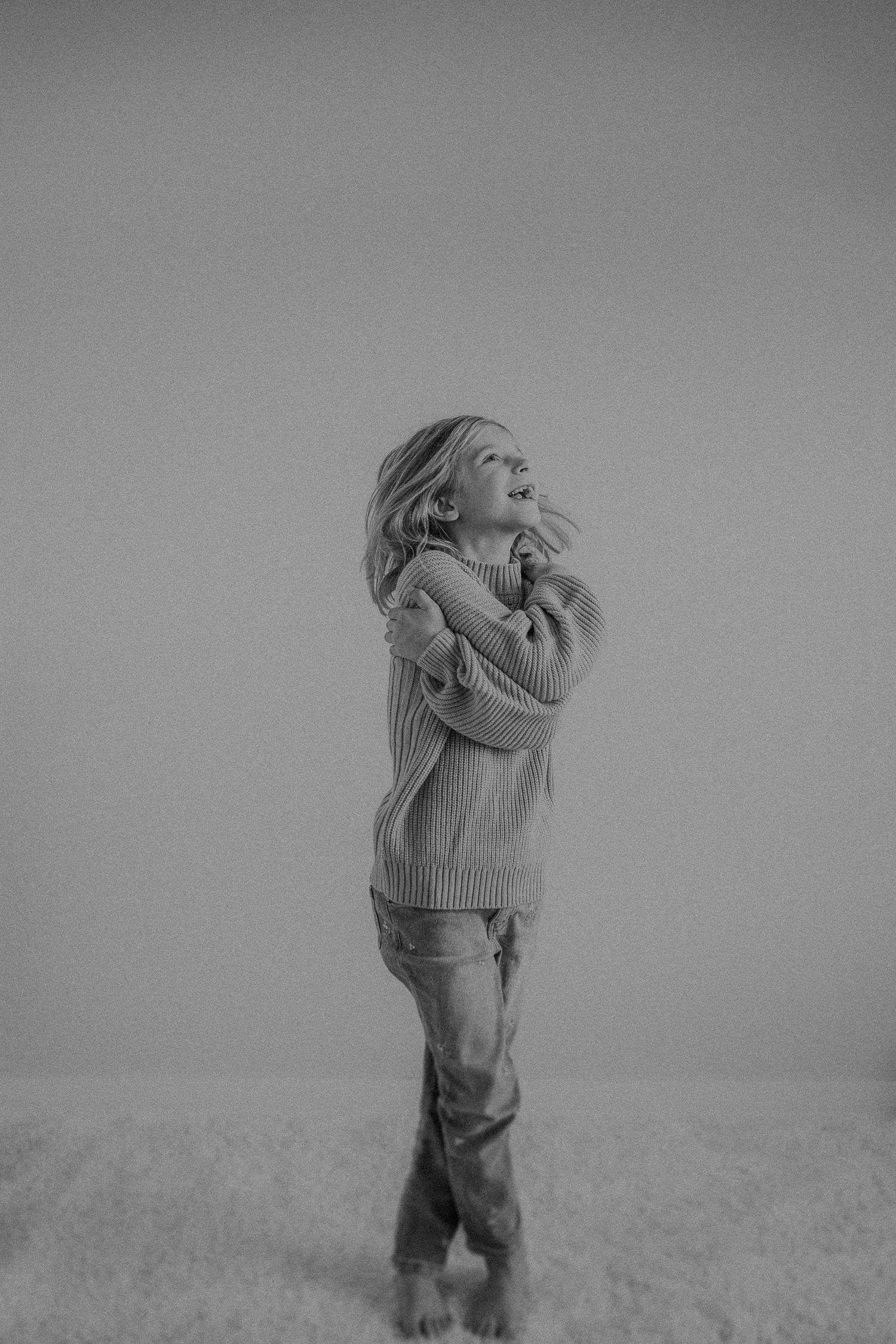 Expressive black and white photo capturing laughter and energy in comfortable casual attire.