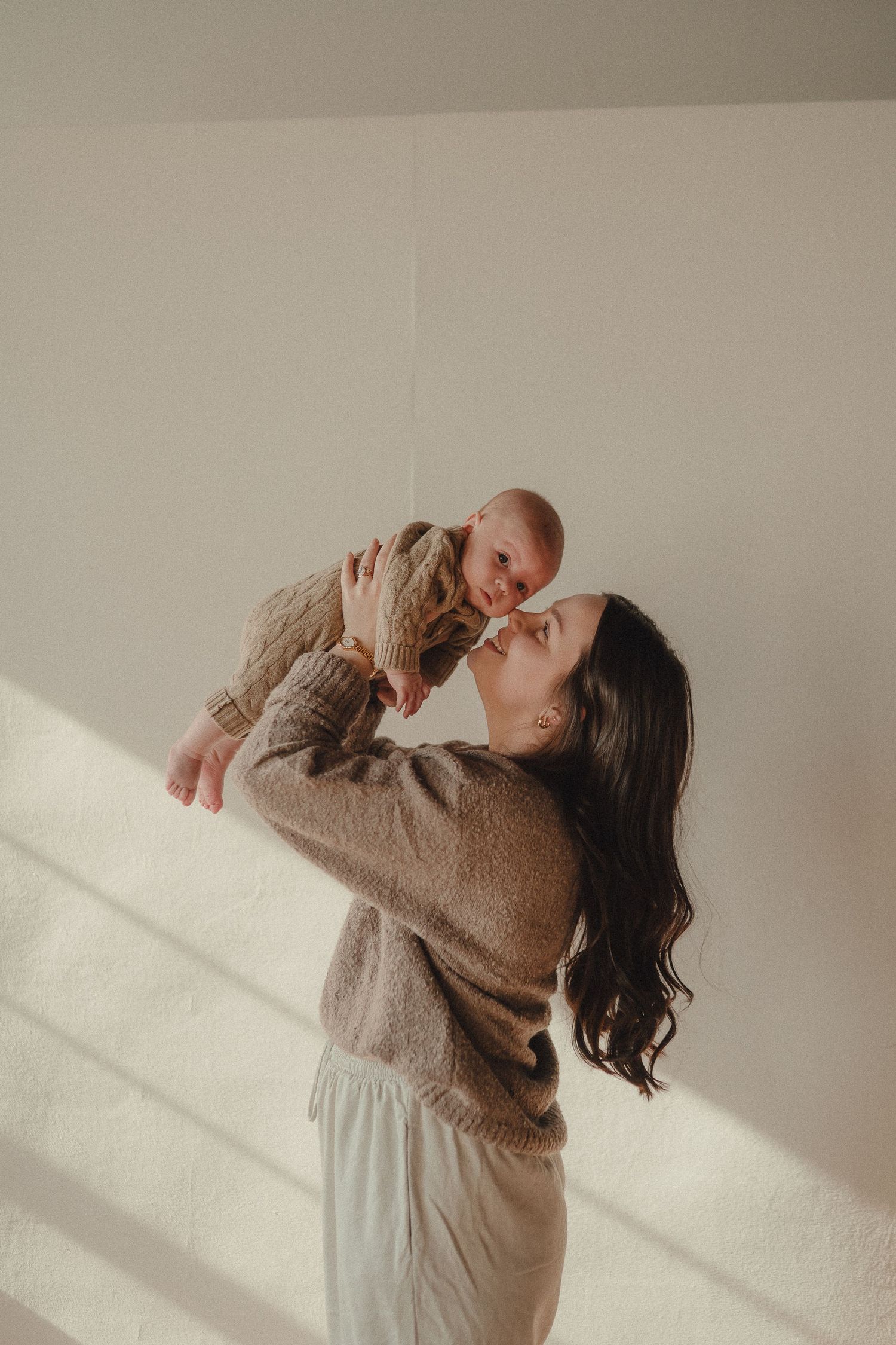 A series of candid dance-like poses against a white wall with dramatic window light and shadows.