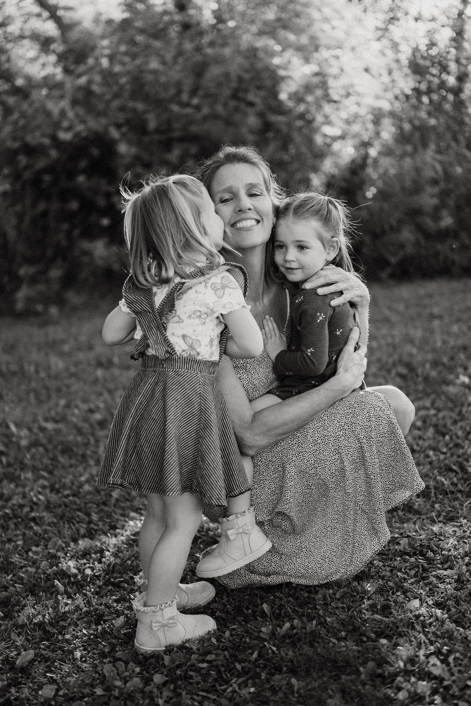 Black and white series of playful moments captured in a grassy outdoor setting.