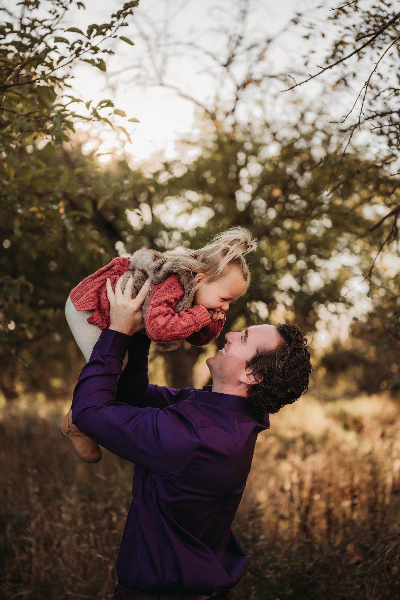 Candid moment of joy captured during sunset in natural outdoor setting.