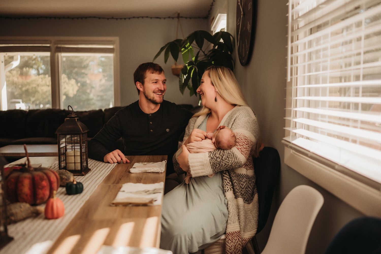 An intimate family scene at a dining table with fall decorations and warm lighting.