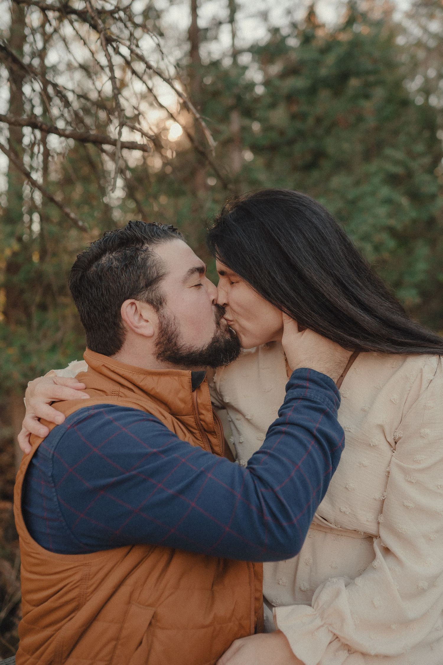 A romantic couple sharing intimate kisses in a series of four outdoor photos with trees in the background.