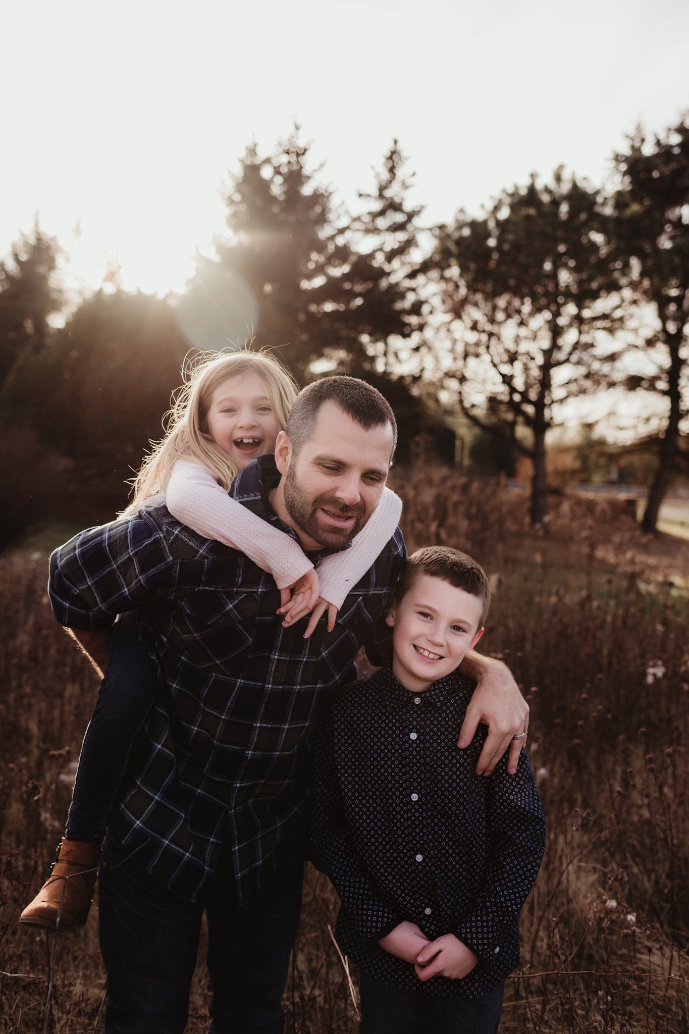 A heartwarming family portrait taken at sunset in a rustic outdoor setting.