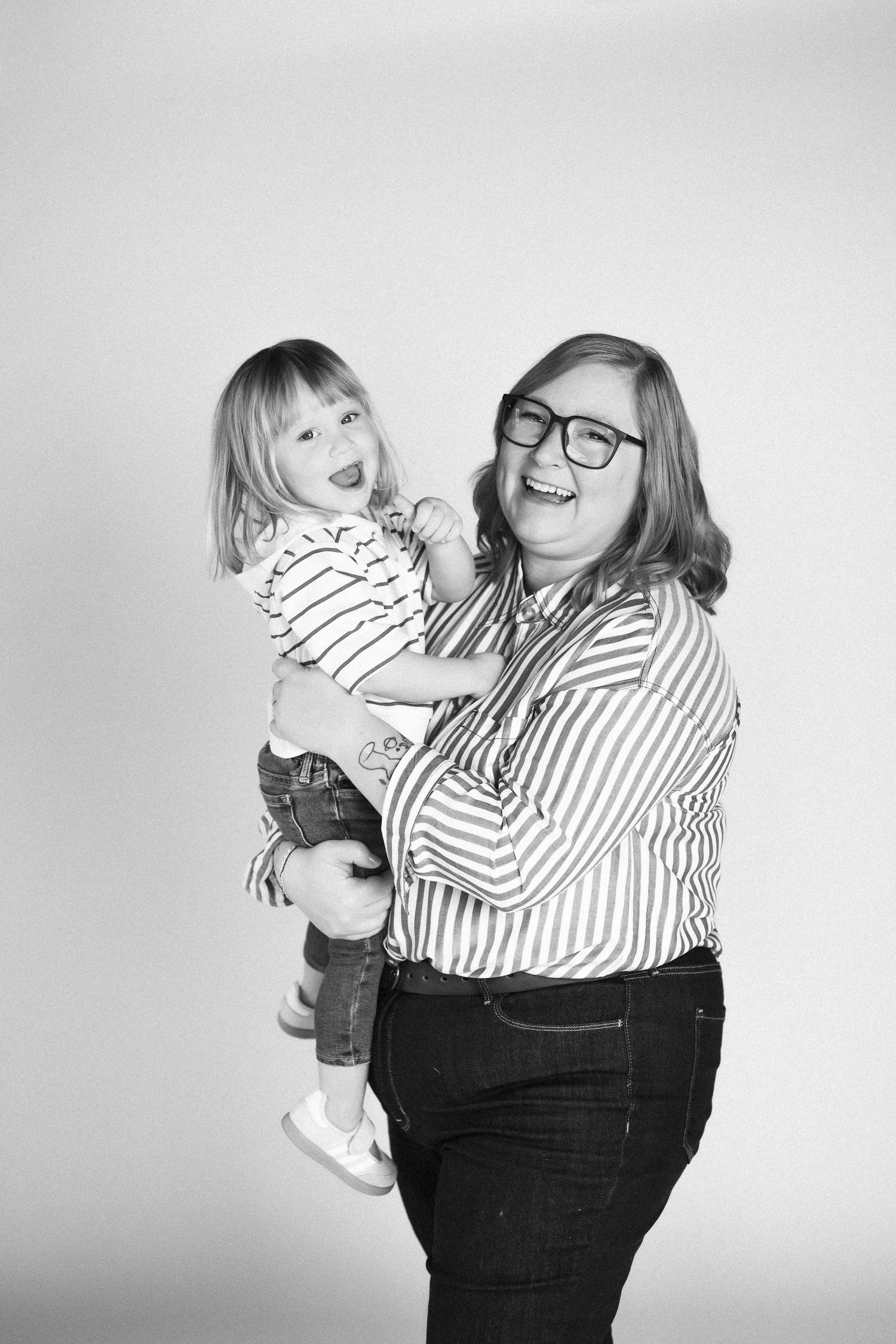 Black and white photos show a parent and child embracing in striped shirts against a light background.