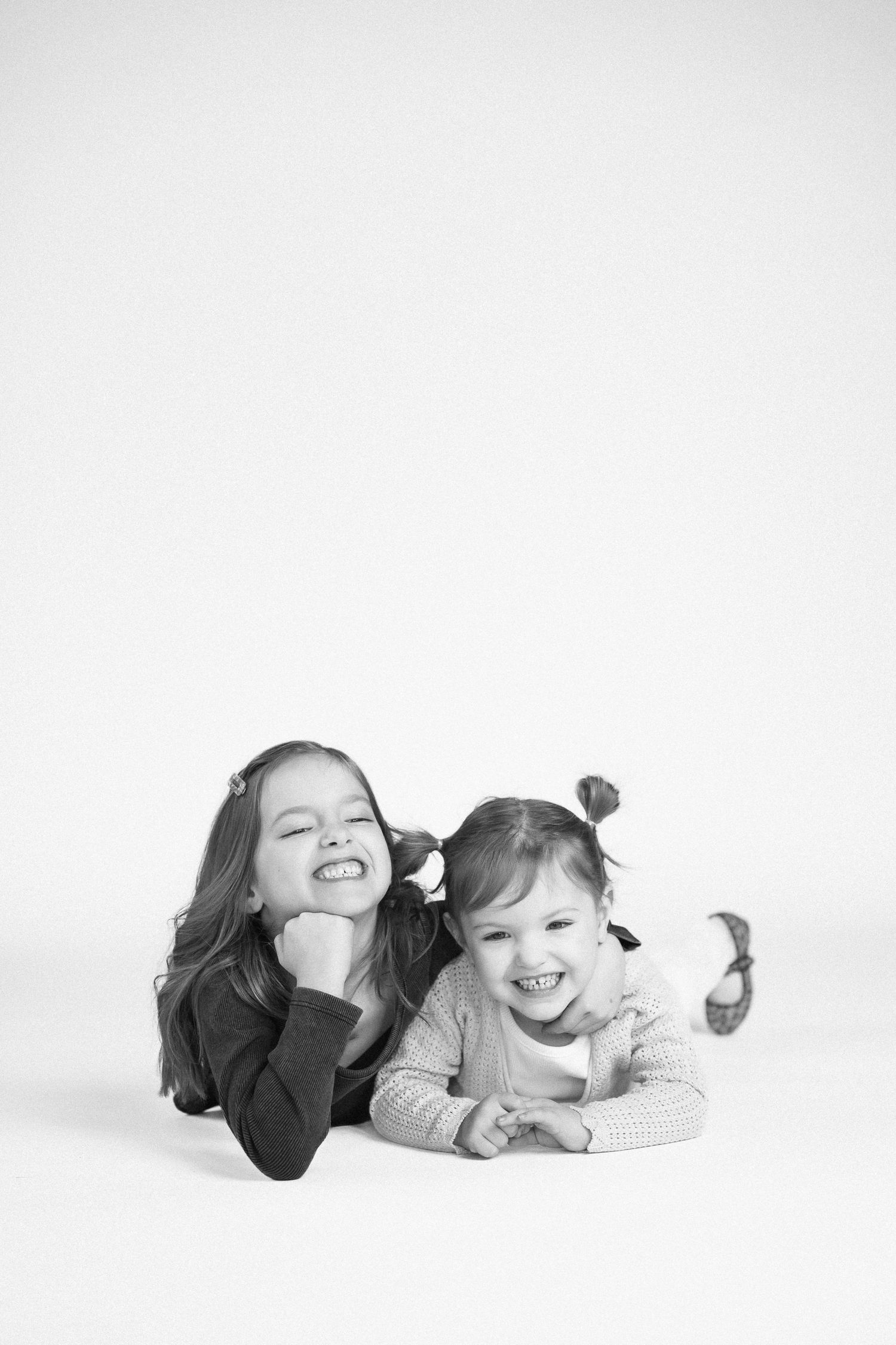 Black and white photo series showing two people lying down and laughing together.
