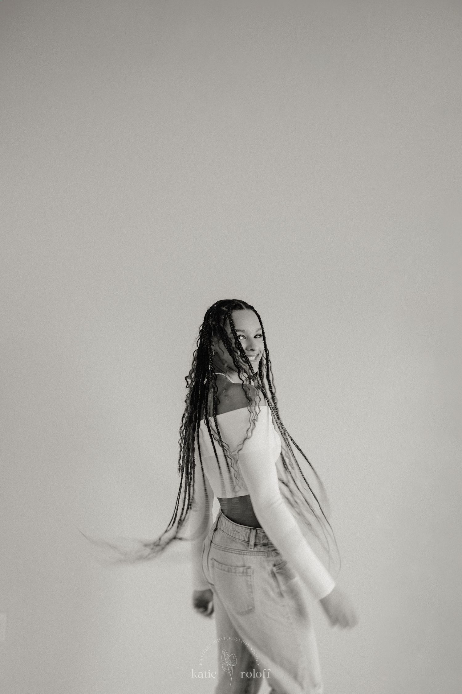 An artistic black and white portrait showing movement and flowing fabric.