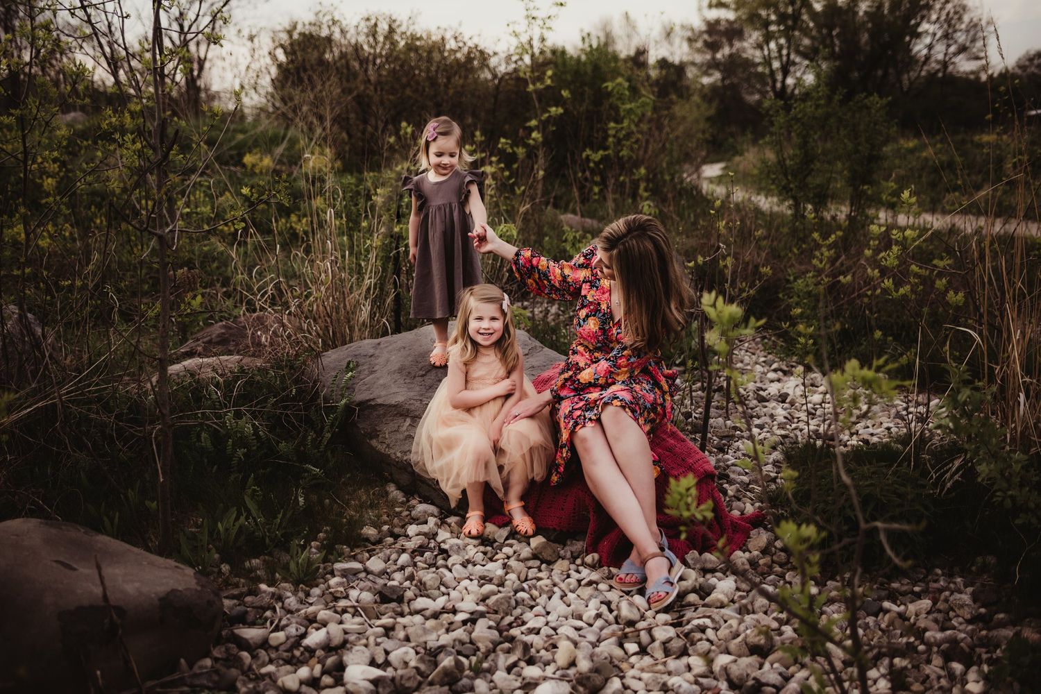 Outdoor lifestyle family portrait on rocky terrain with natural lighting.