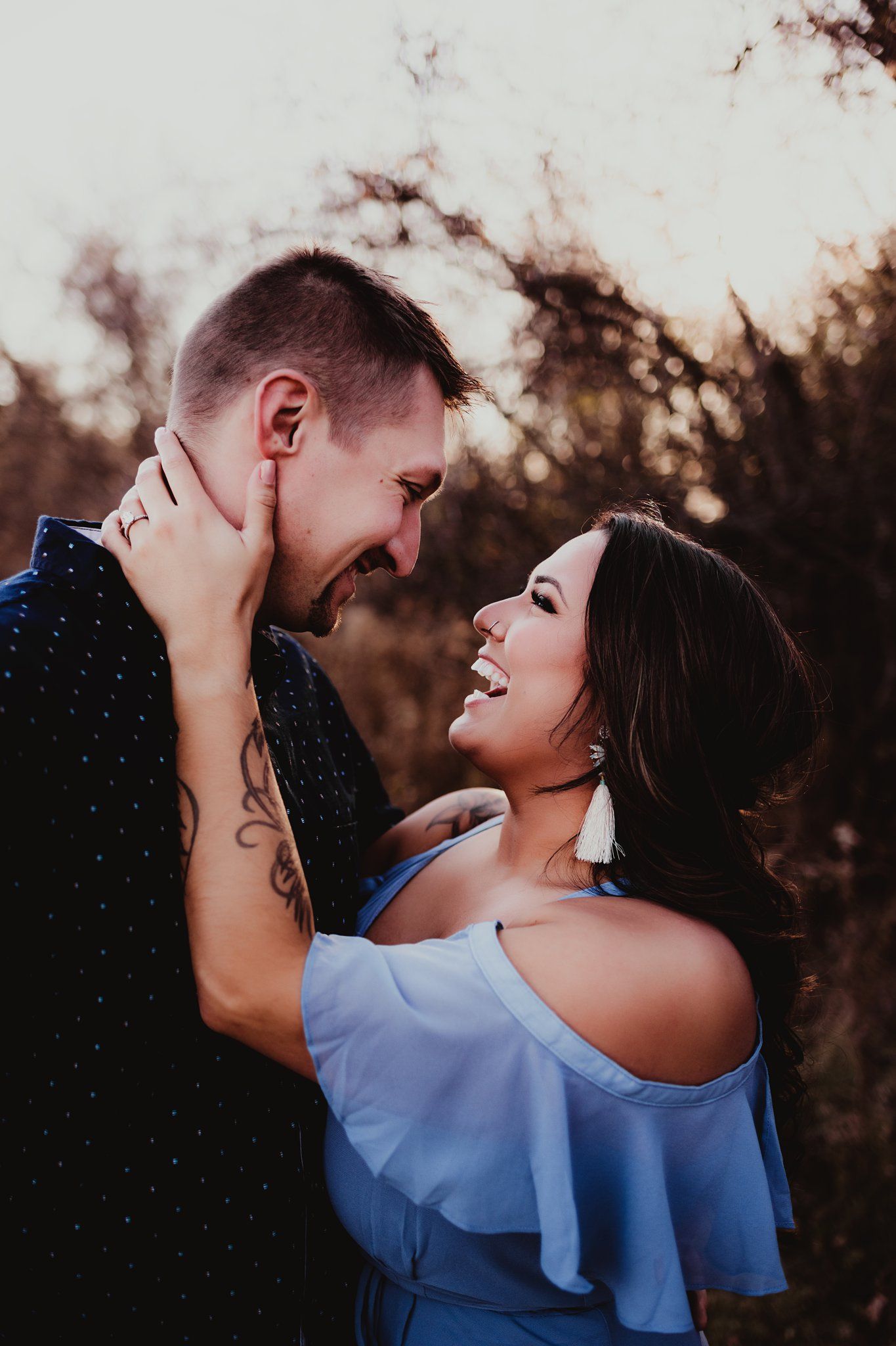 A romantic engagement photo featuring a couple in blue attire sharing an intimate moment.