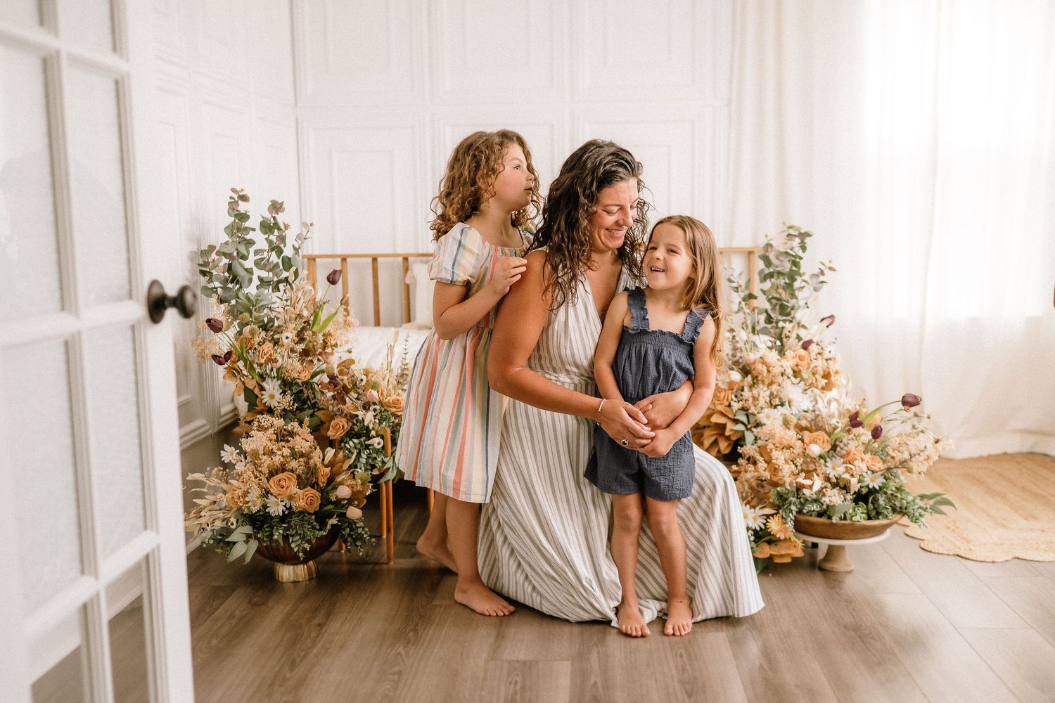 Lifestyle family photography with peach floral arrangements and natural lighting.