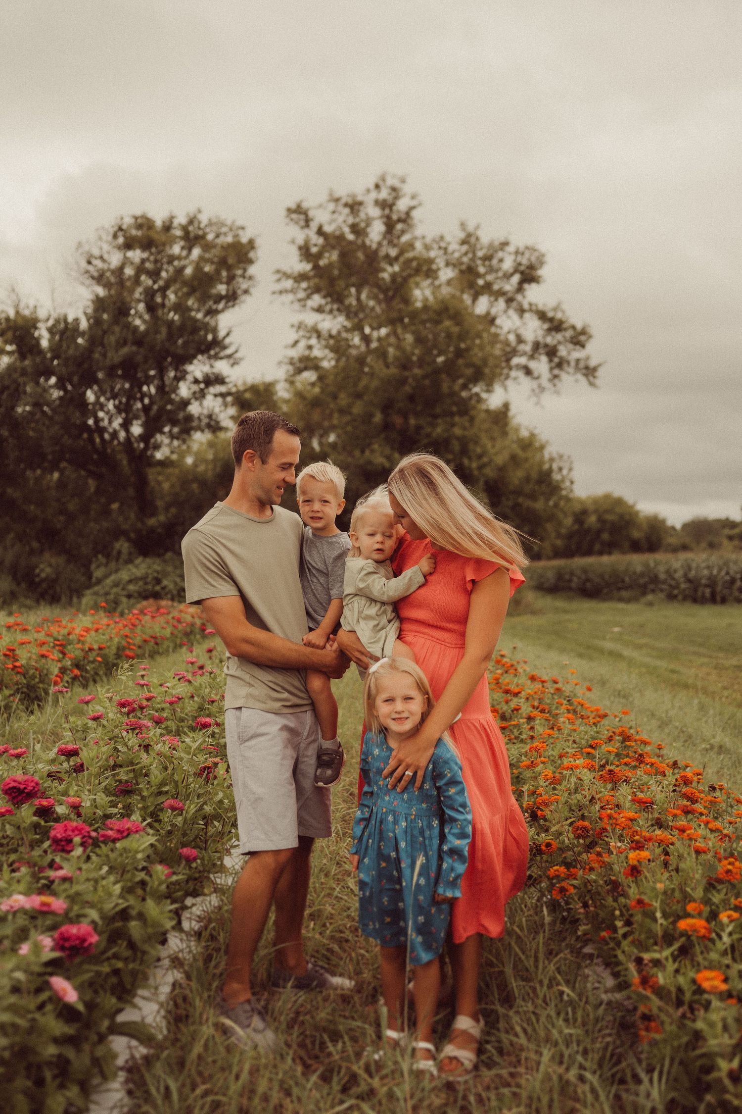 Loving family moment captured in a field of colorful wildflowers at sunset.