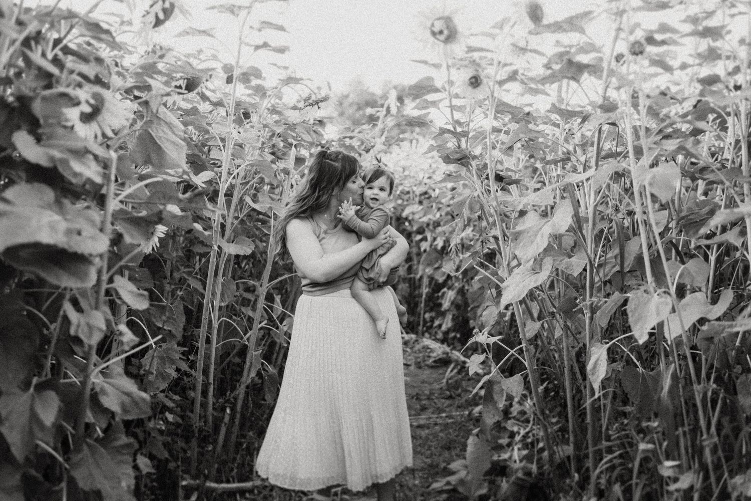 Black and white portrait in a sunflower field during summer.