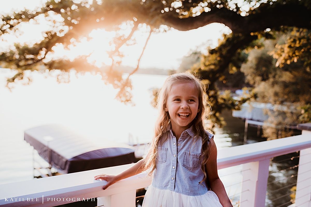 A joyful moment captured at sunset on a wooden dock by the water.