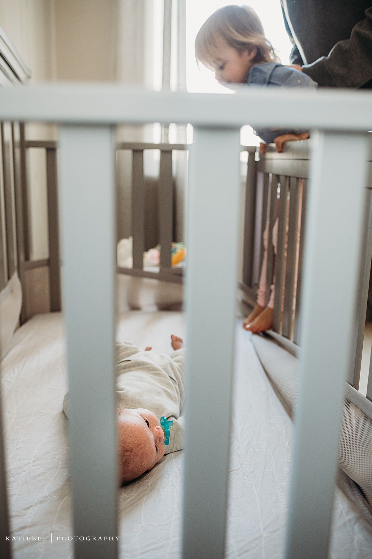 View through white crib bars shows peaceful nursery setting.