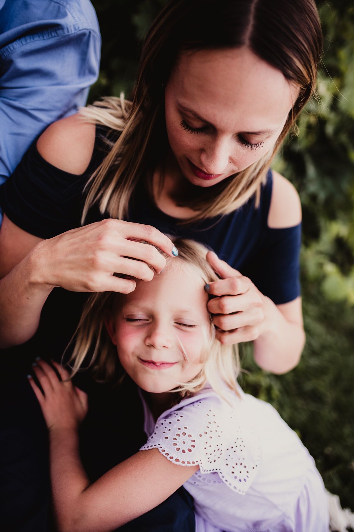 Tender moment between family members sharing affection outdoors.
