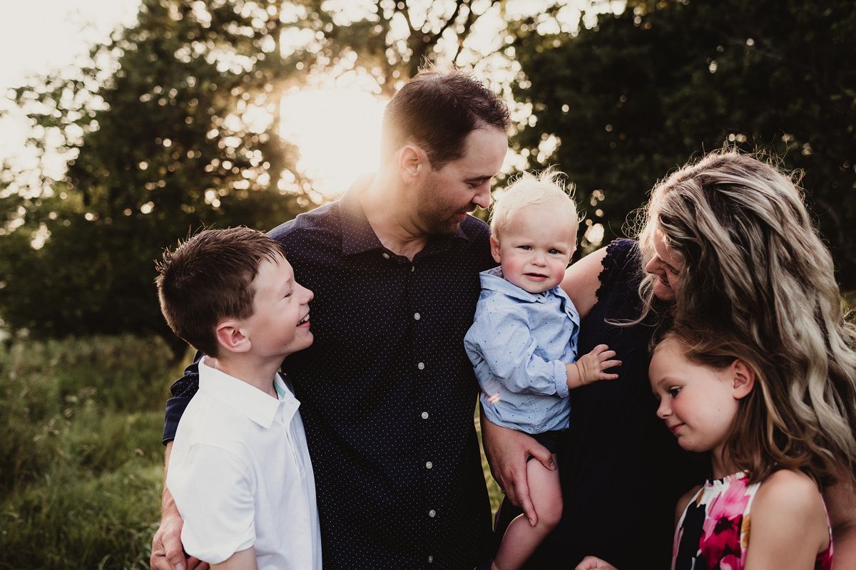A family shares an intimate moment together outdoors at sunset.