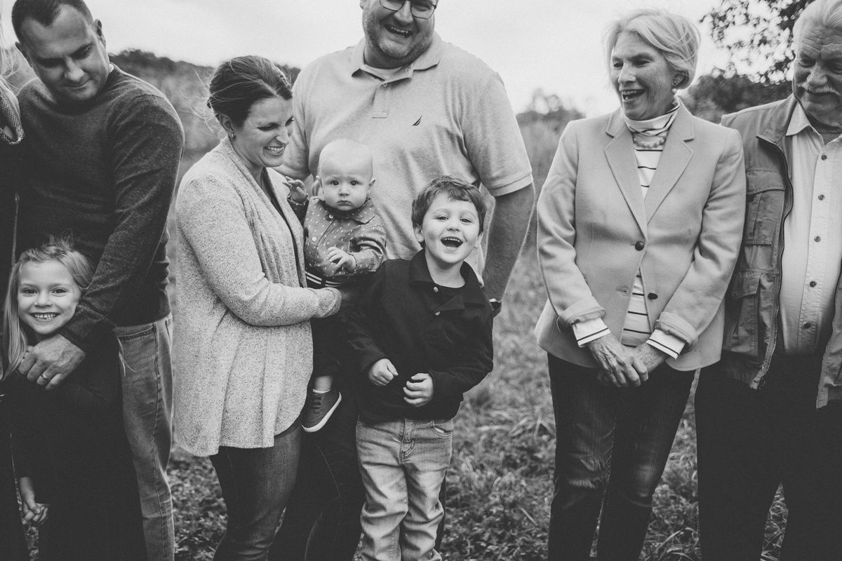 Black and white candid family photo of multi-generational gathering outdoors.