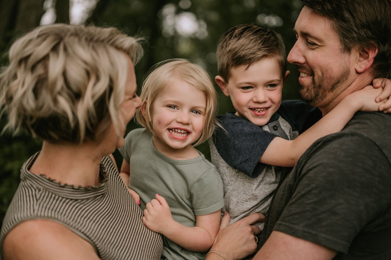 Candid family portrait showing joyful expressions and natural interaction outdoors.