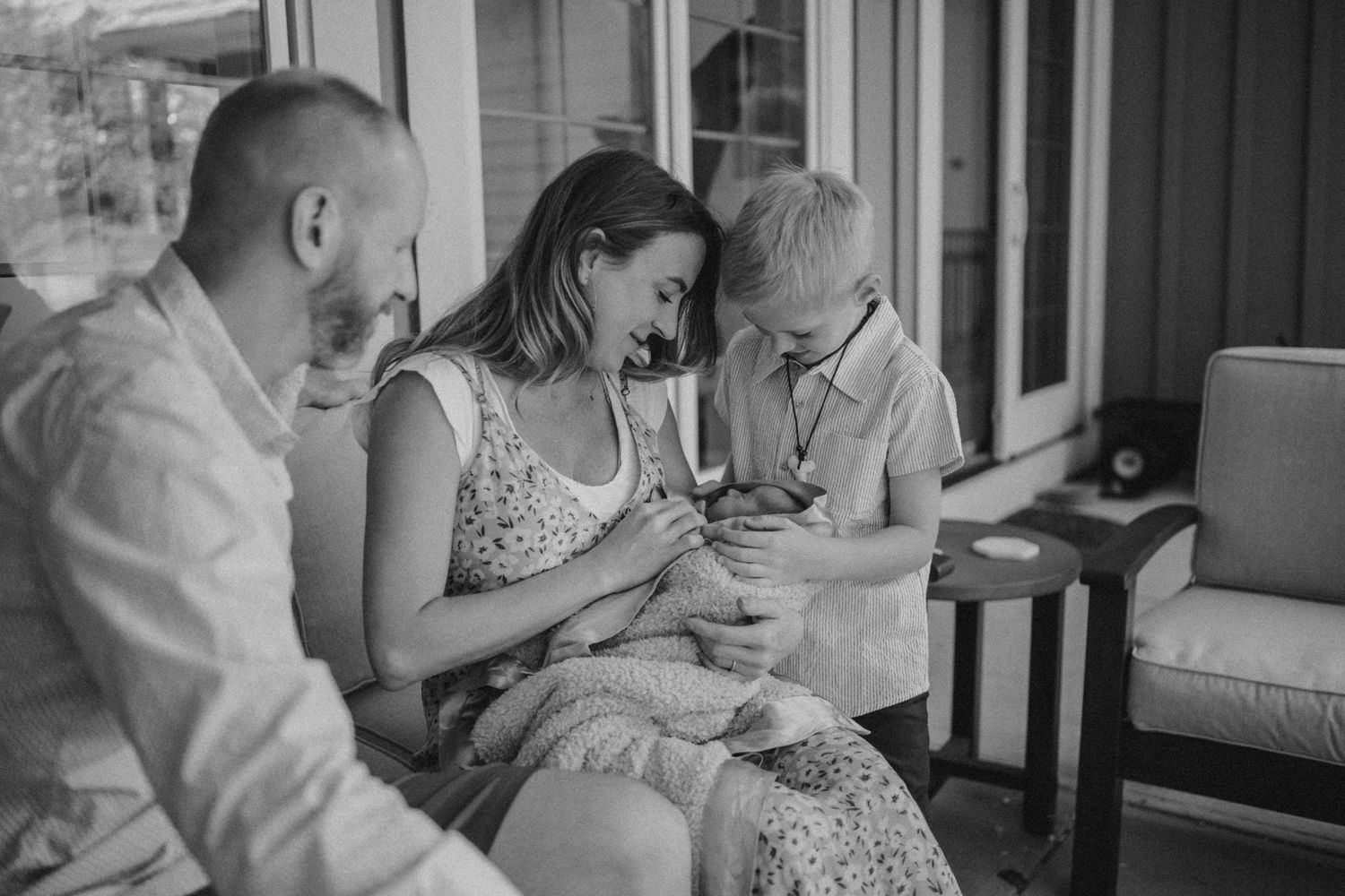 Candid moment shared on outdoor porch furniture with natural lighting.