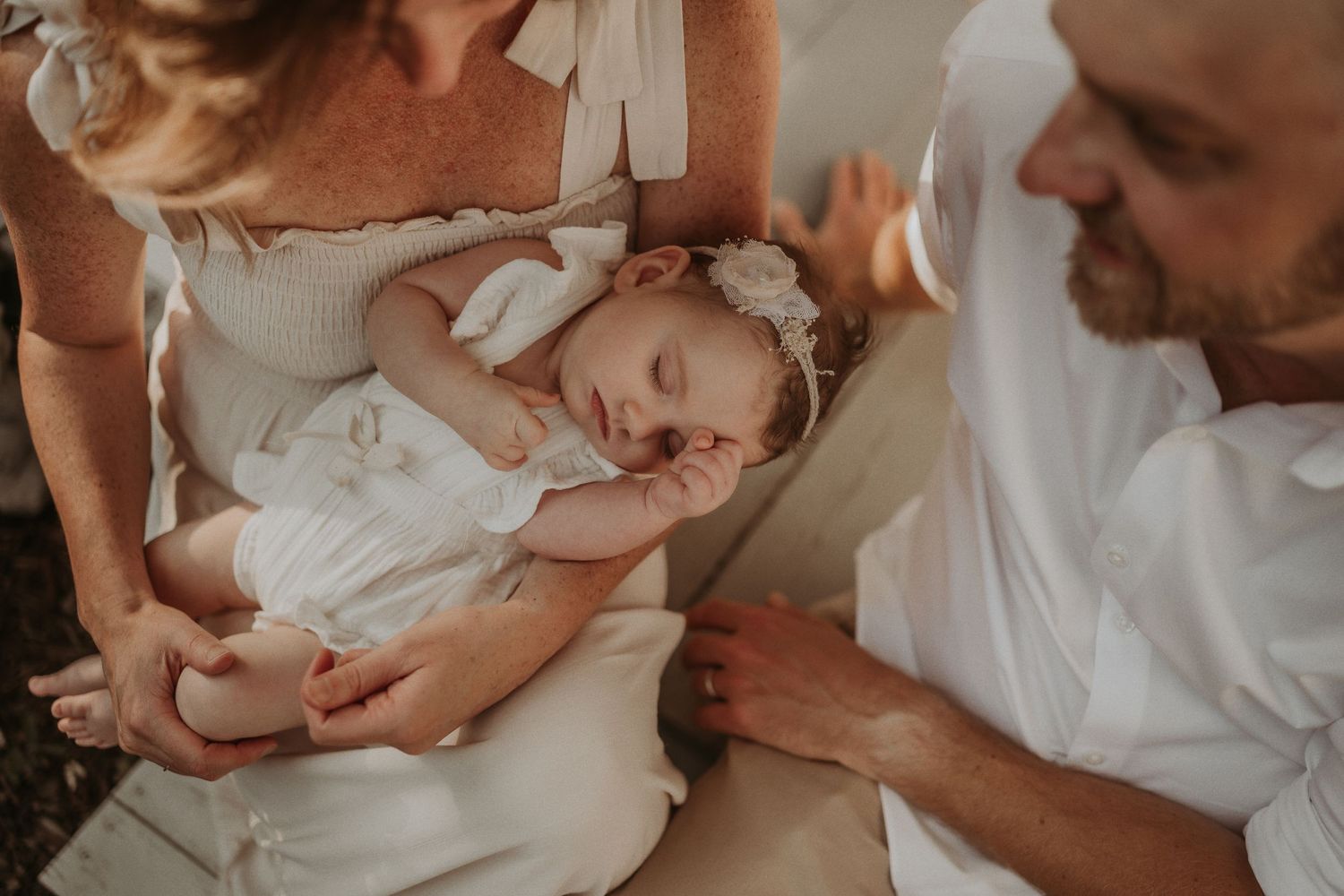 Warm-toned intimate family portrait on a sun-drenched porch.