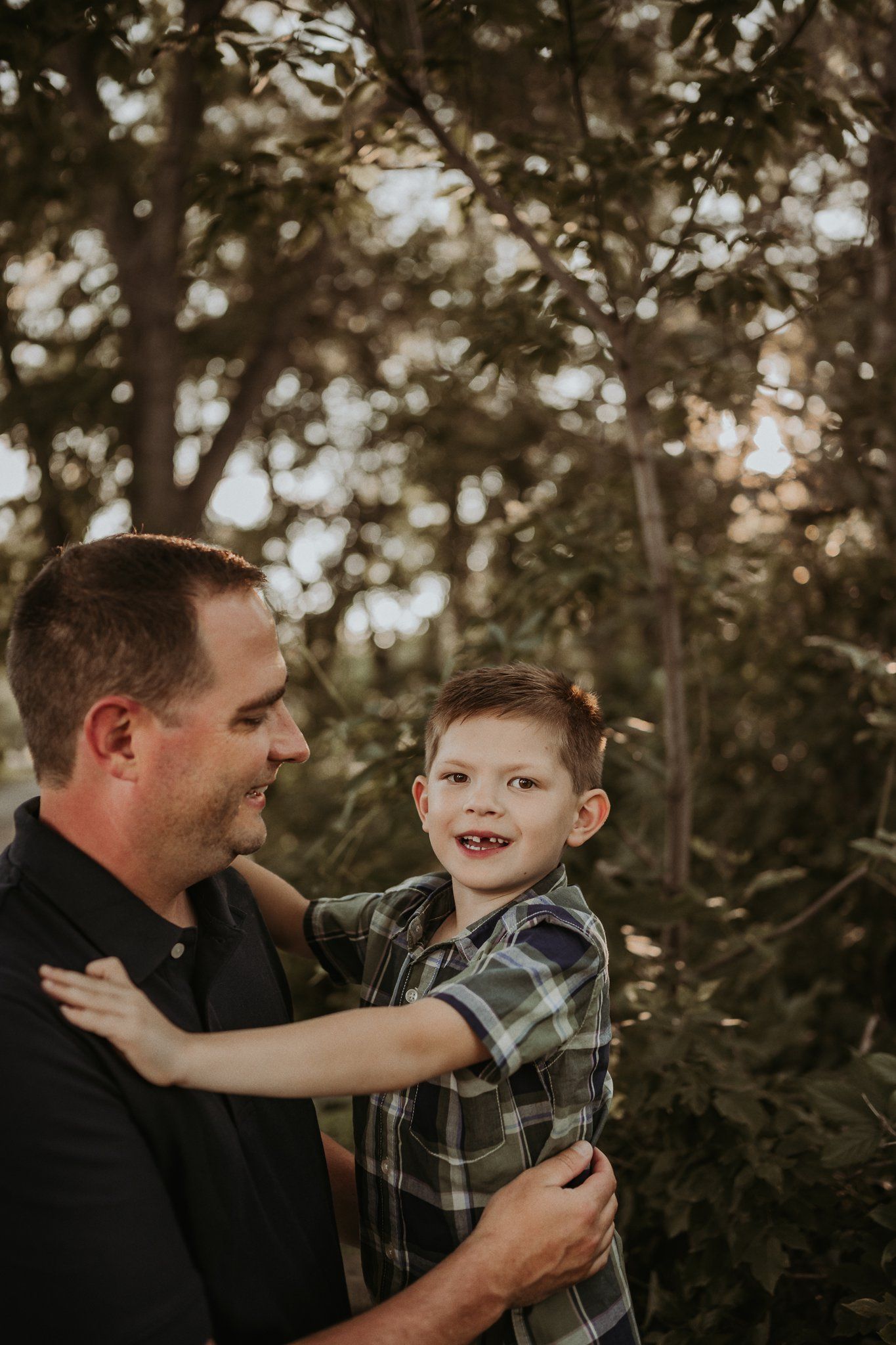Candid outdoor portrait capturing a joyful moment between parent and child.