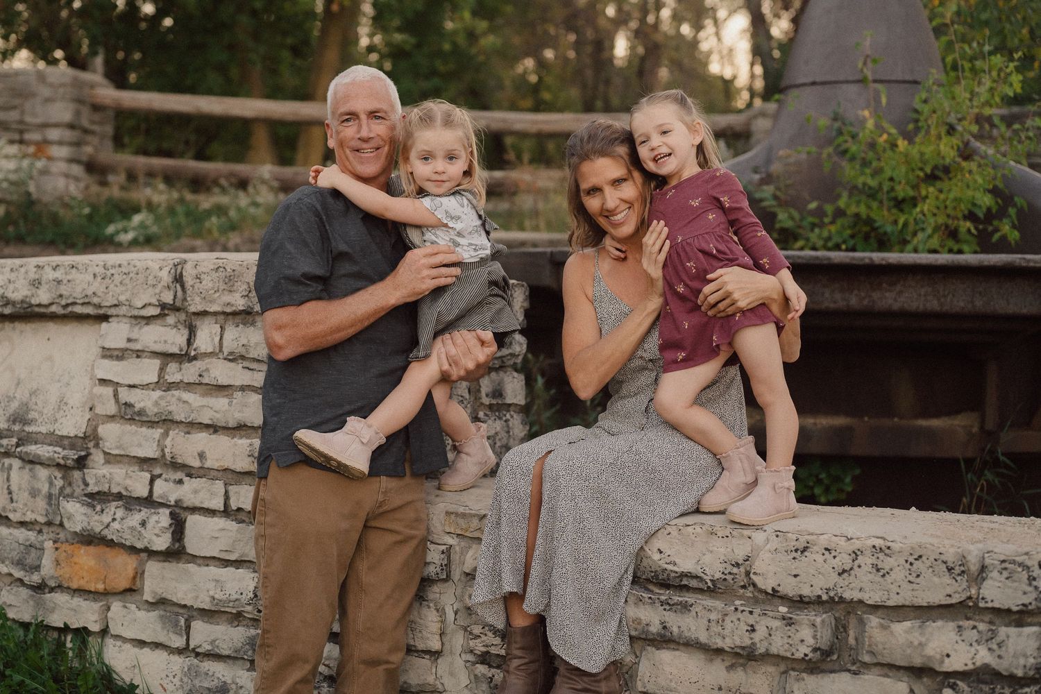 A family shares joyful moments together while sitting on rustic stone steps during an outdoor photo session.