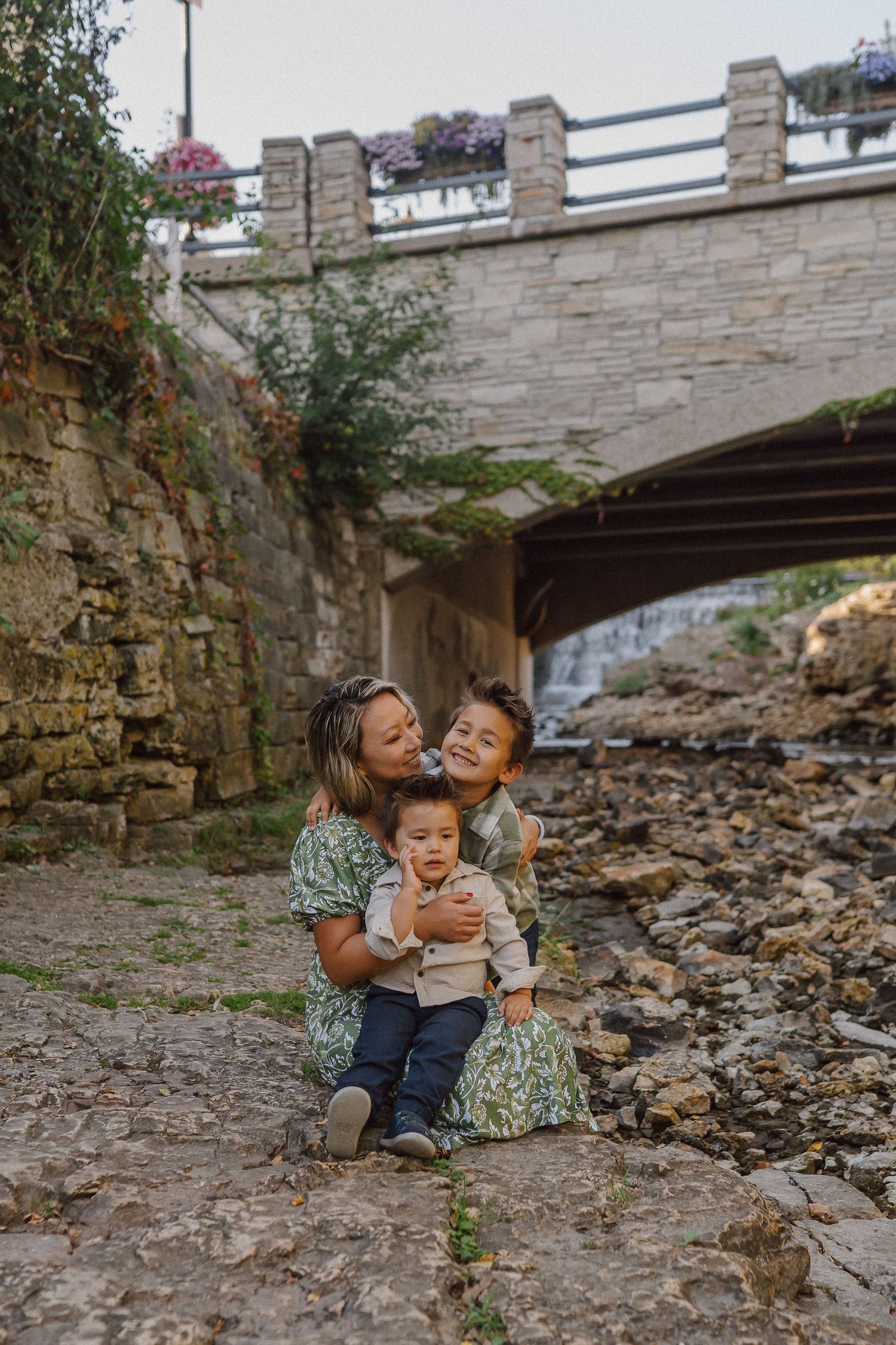 A playful moment captured under a stone bridge on a rocky embankment.