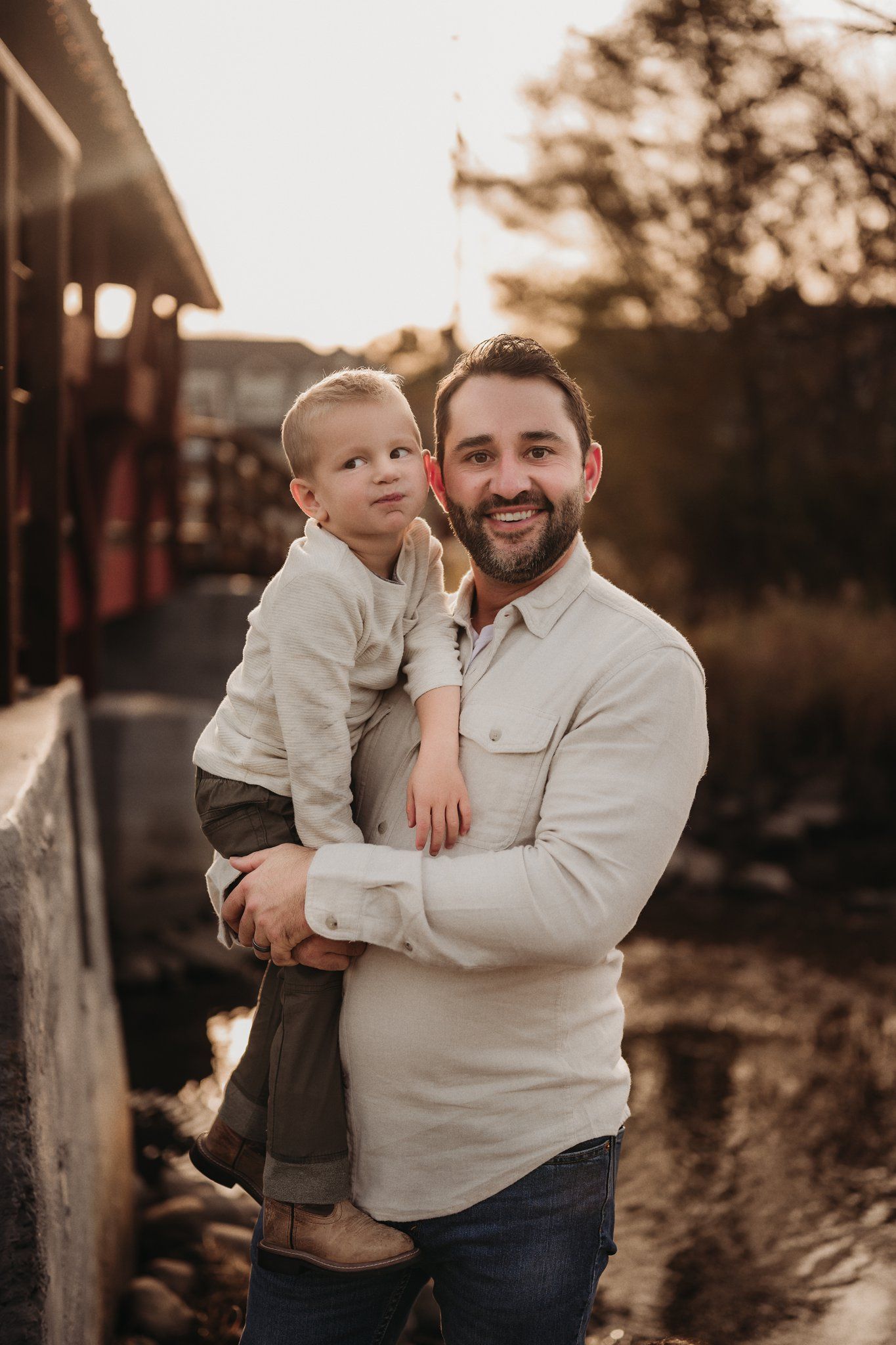 Warm sunset portrait on rustic wooden fence backdrop.