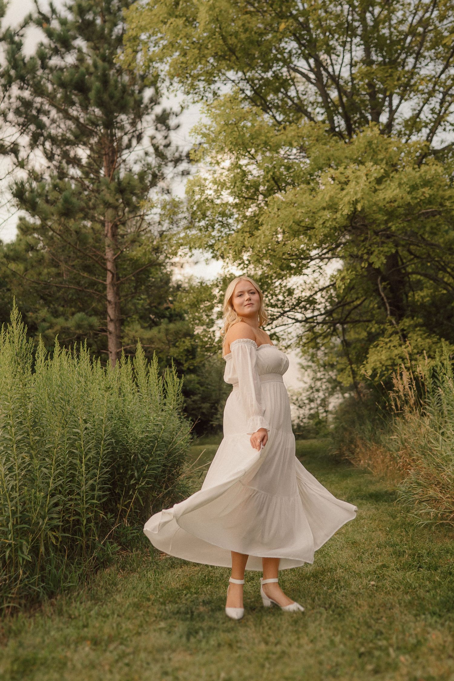 A series of whimsical outdoor photos showing a person twirling in a flowy white dress and ballet flats in a garden setting.