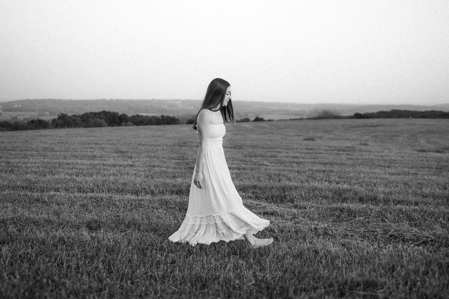 A collection of black and white photographs showing a person in a flowy dress twirling in an open field.