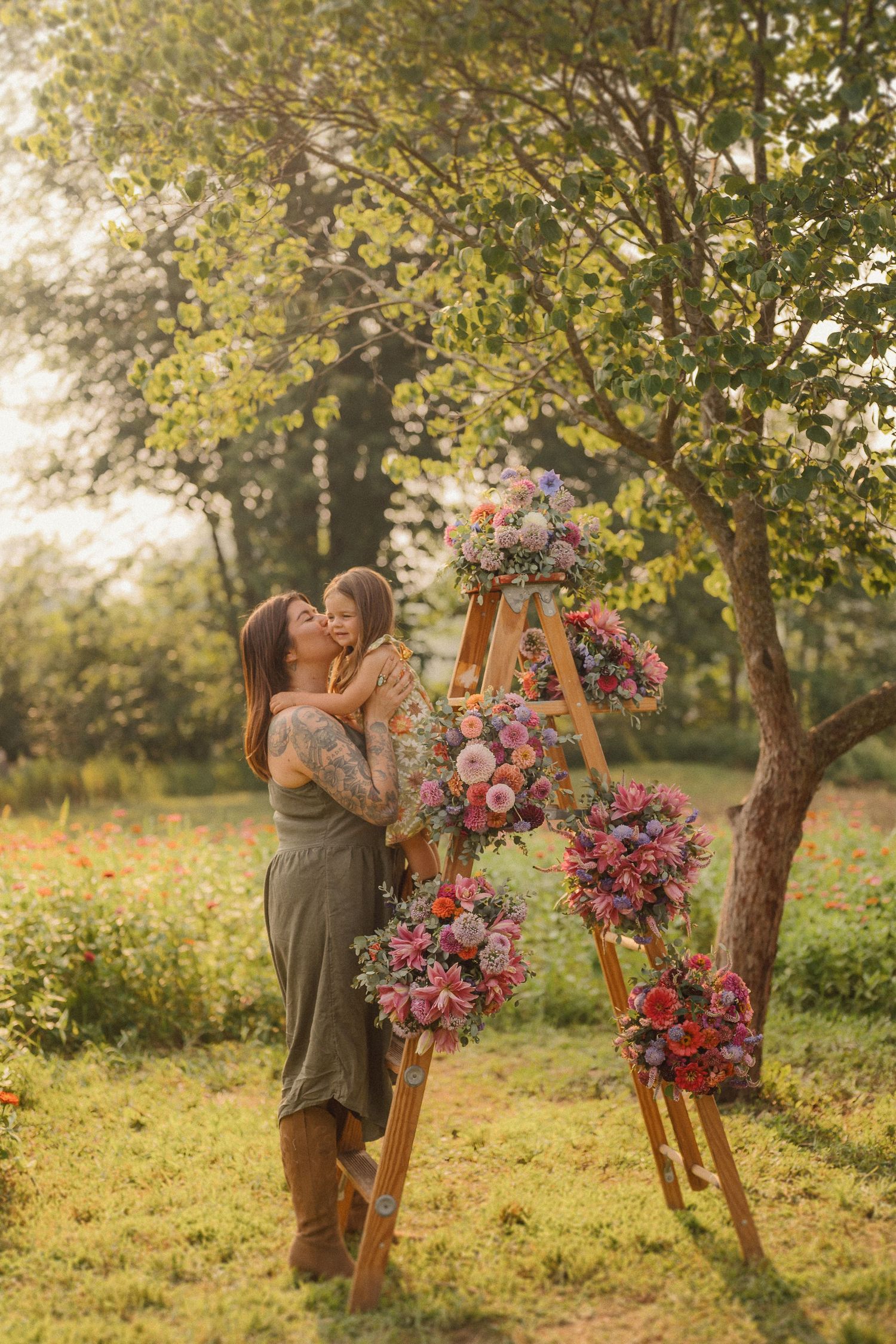 Romantic outdoor photo session featuring a wooden arch adorned with pink and purple florals at sunset.