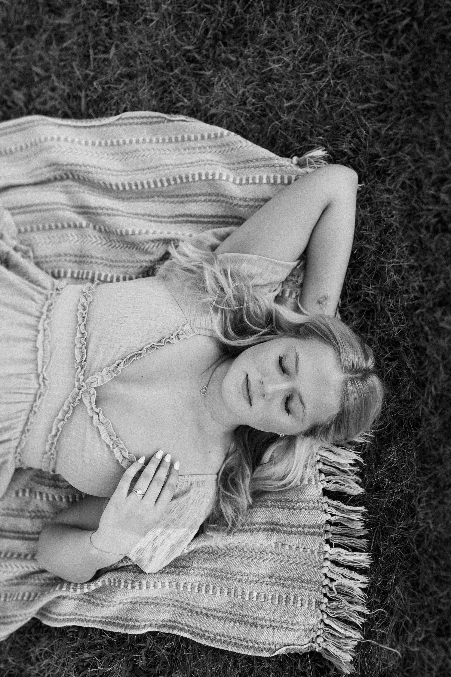 Black and white portrait on a textured blanket with delicate lace details.