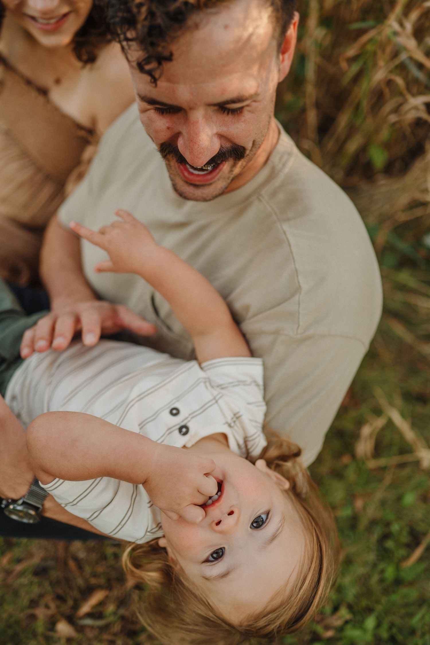 A playful moment captured outdoors with joyful expressions amid natural surroundings.