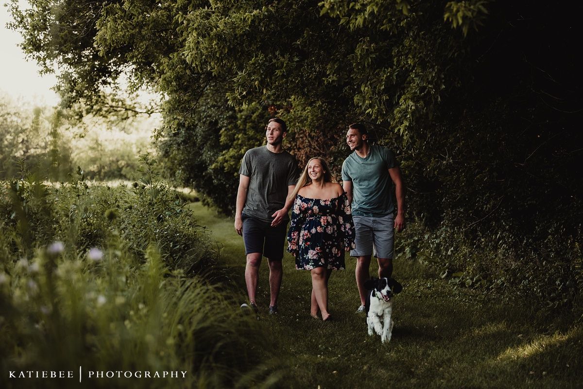 Group walking on nature path with their border collie during golden hour.