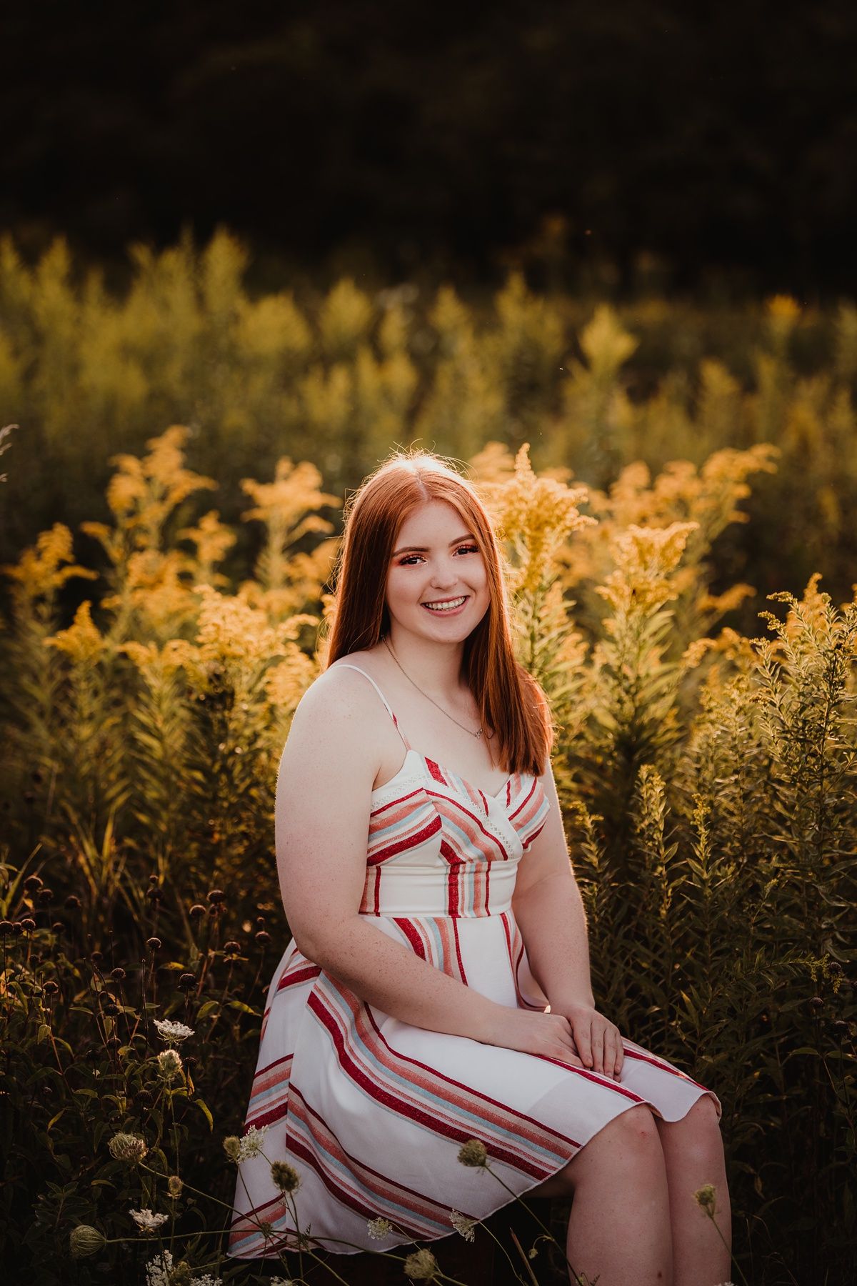 A romantic portrait in a field of golden wildflowers at sunset.