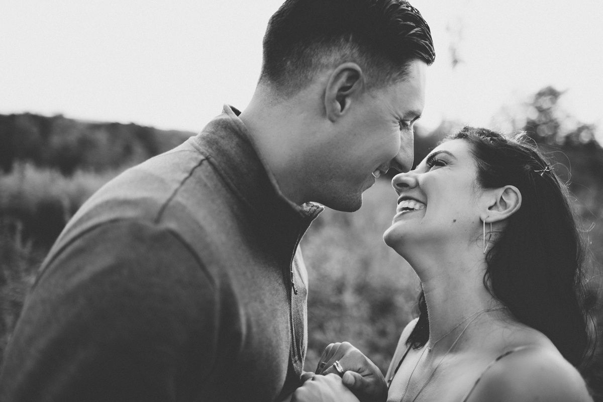 Black and white portrait of couple in a tender moment outdoors.